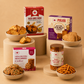 Polka healthy snack hamper with Desi Ghee Rusk, Atta-Millet cookies, High Protein Multiseed cookies, and Peri Peri puffs.